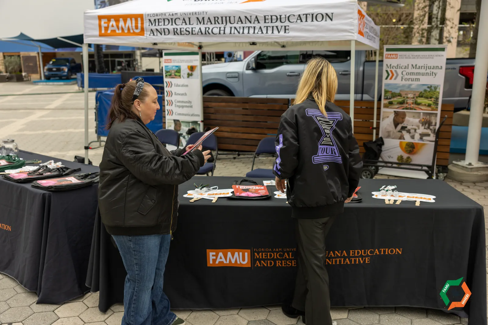 a couple of women standing next to a table with food on it