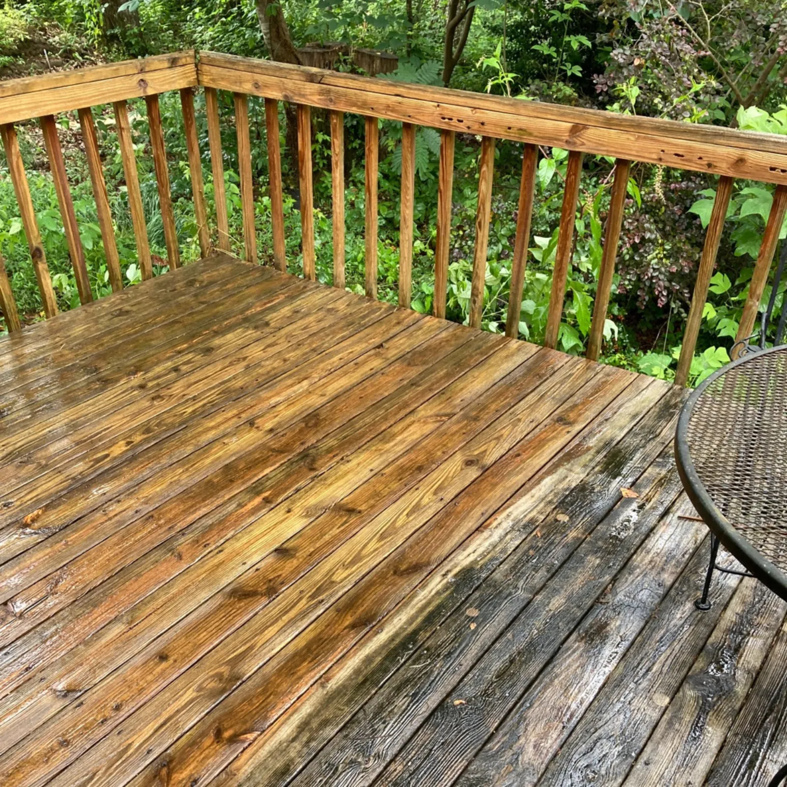 a wood deck with a chair and a table and trees in the background