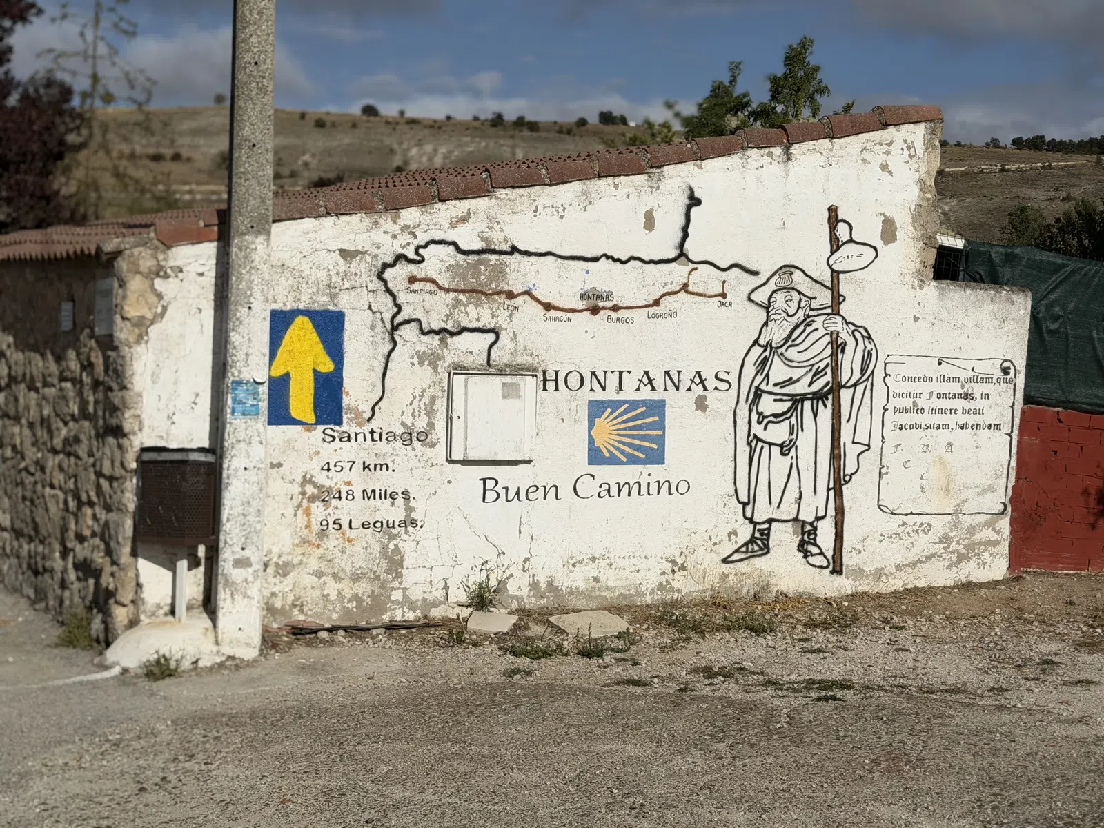 Wall mural in Hontanas showing the Camino de Santiago route with pilgrim figure and distance information