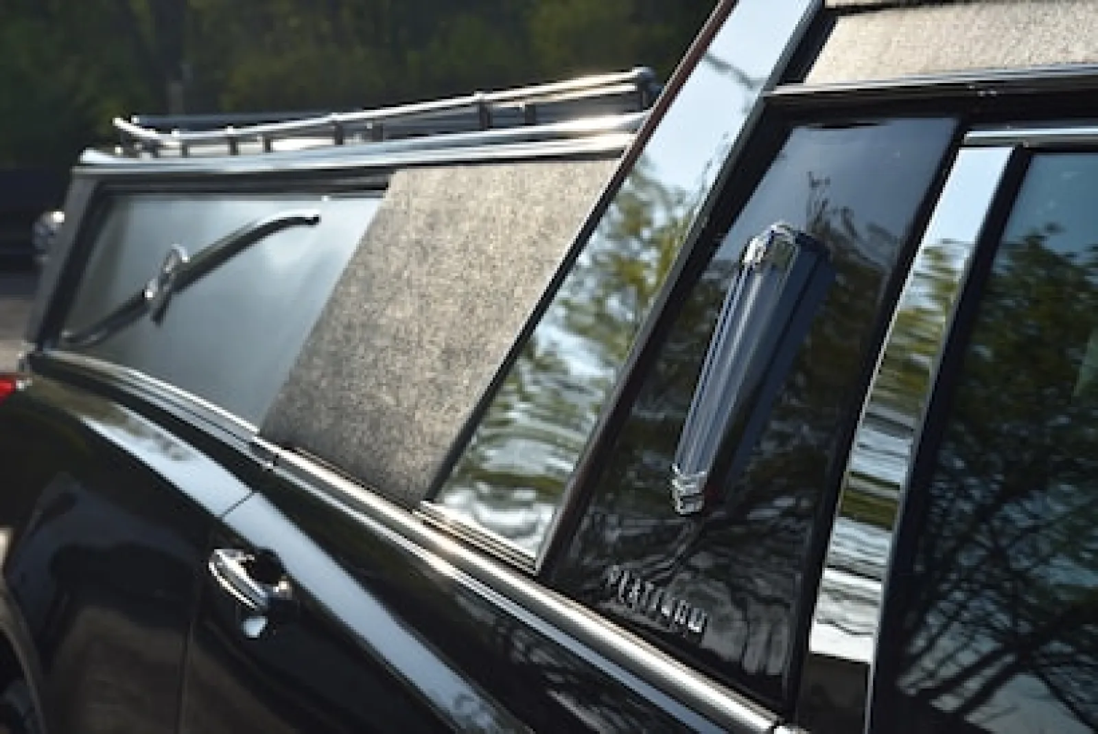 Close-up of a luxury hearse, highlighting polished chrome, sleek design, and elegant finish.