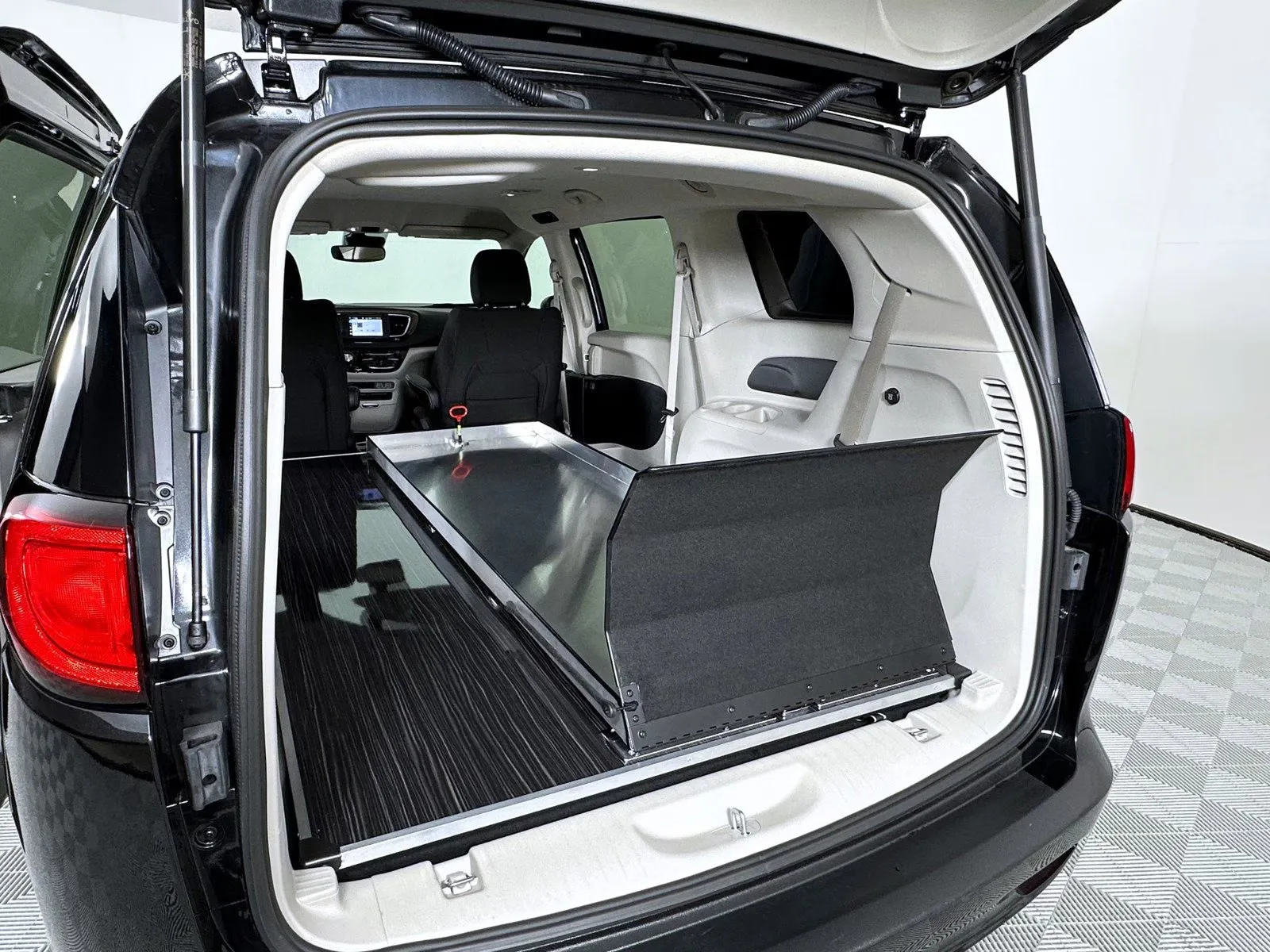 Interior view of a spacious trunk in a black SUV with a sliding storage unit.