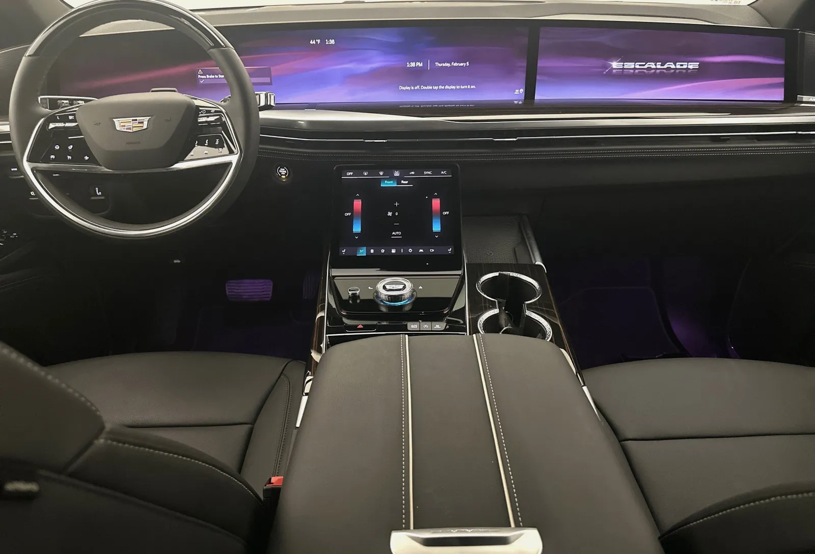 Interior view of a Cadillac Escalade with digital dashboard, touchscreen controls, and luxury leather seats.