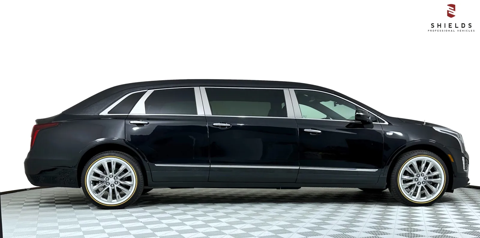 Black luxury limousine with chrome accents, parked on a checkered floor background.