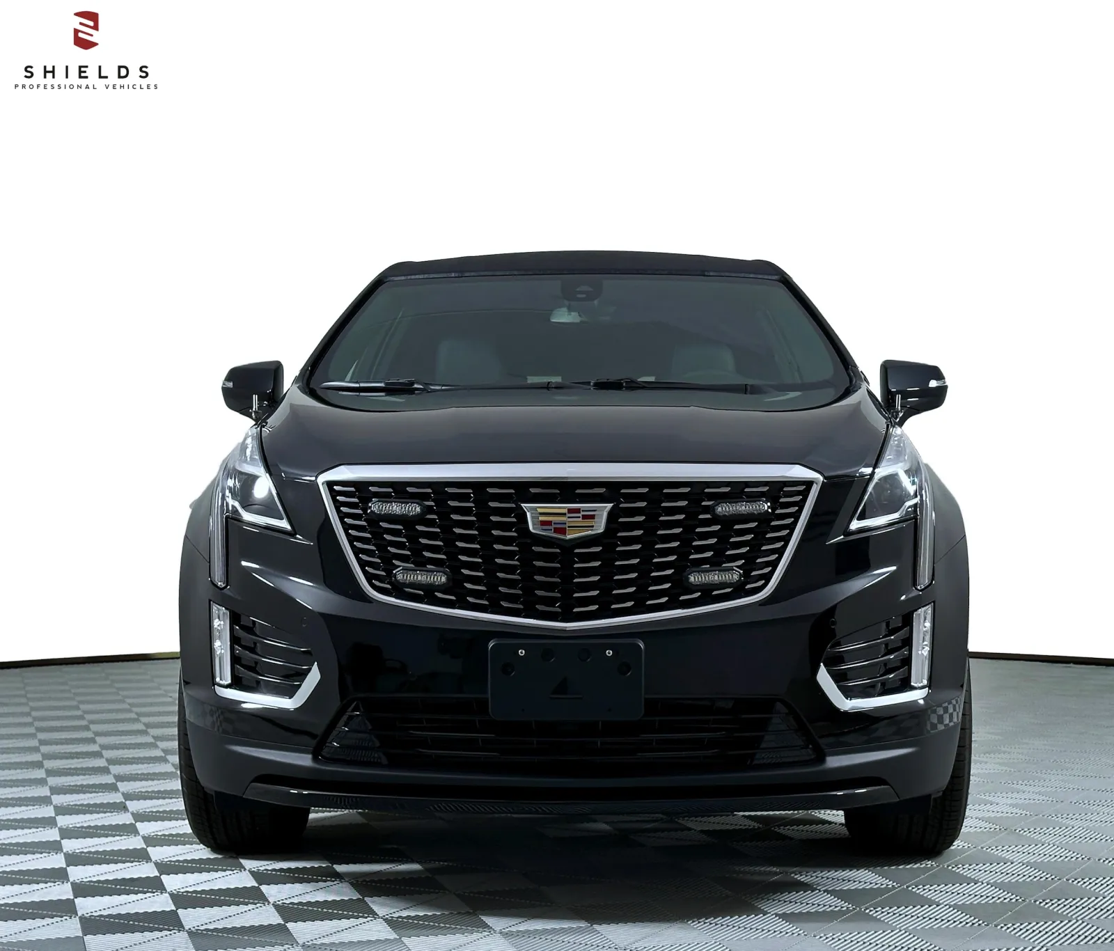 Front view of a sleek black Cadillac SUV with distinctive grille and modern design.