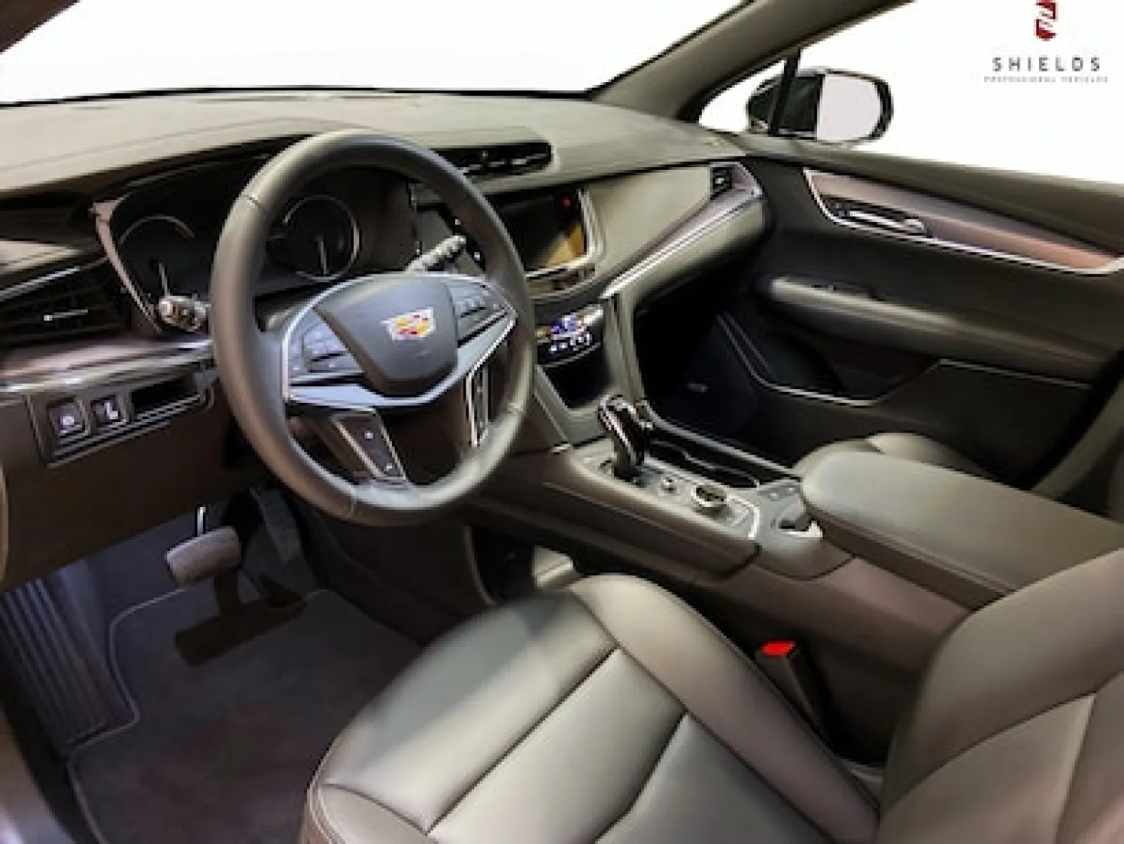 Luxurious Cadillac car interior featuring leather seats and modern dashboard design.
