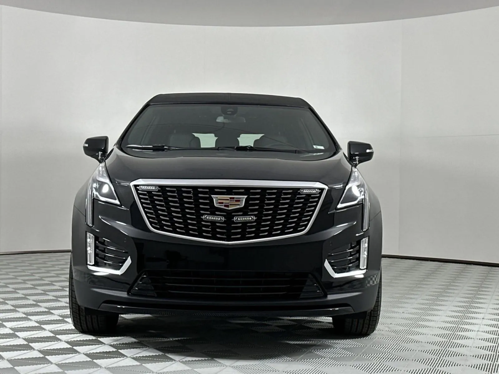 Front view of a sleek black Cadillac SUV displaying modern design features.