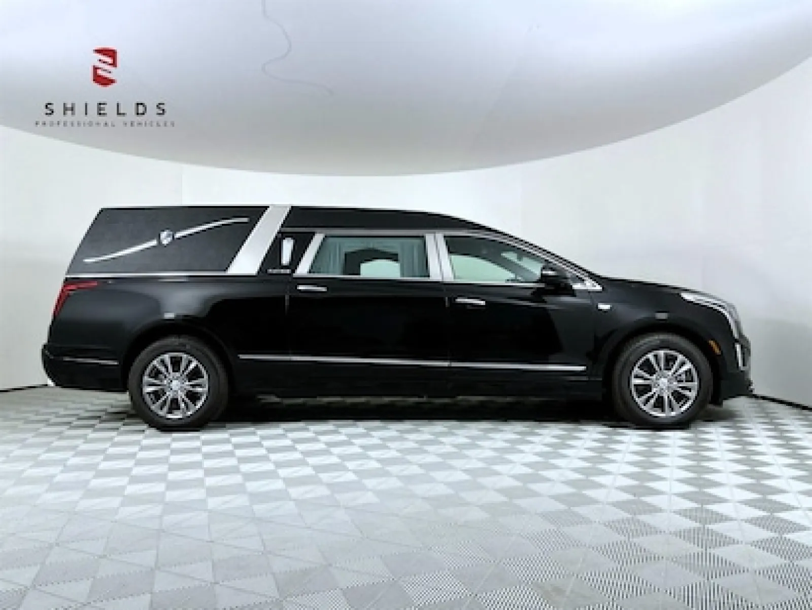 Black hearse vehicle showcased in a modern display environment with sleek design features.