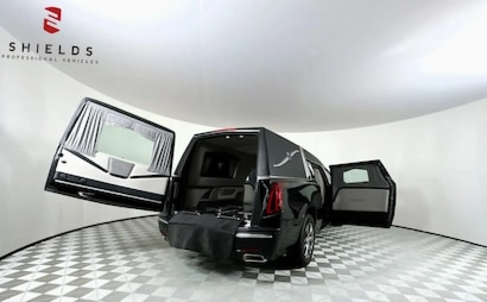 Luxury hearse with open doors showcased in a modern showroom setting.