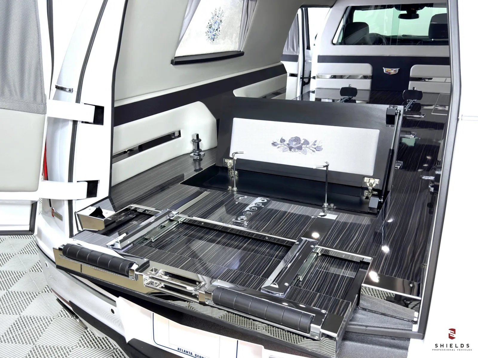 Luxury hearse interior featuring sleek chrome accents and refined wooden details.