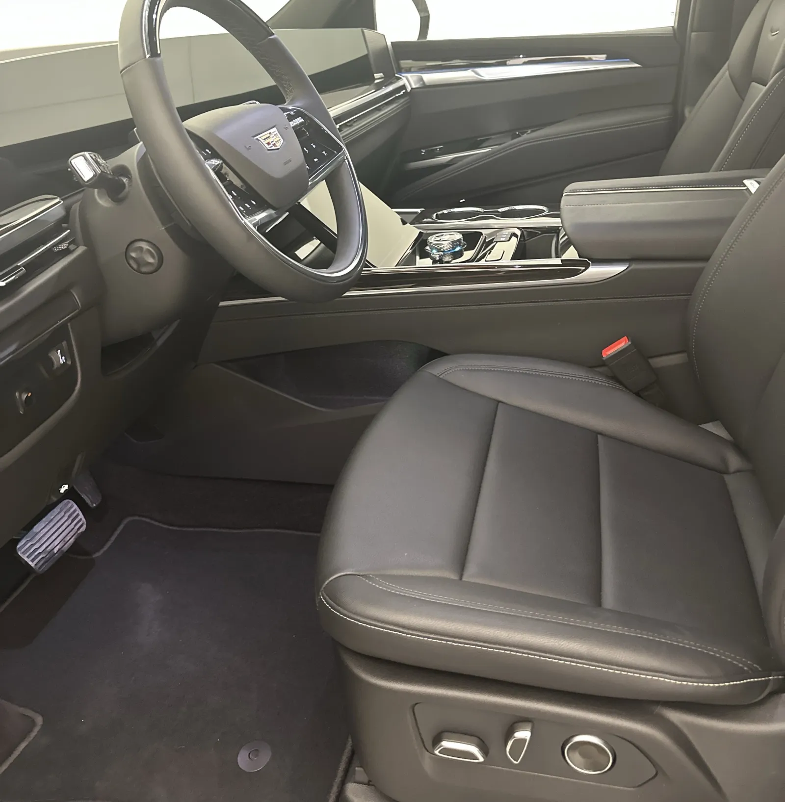 Luxury car interior with black leather seats, digital dashboard, and modern steering wheel controls.