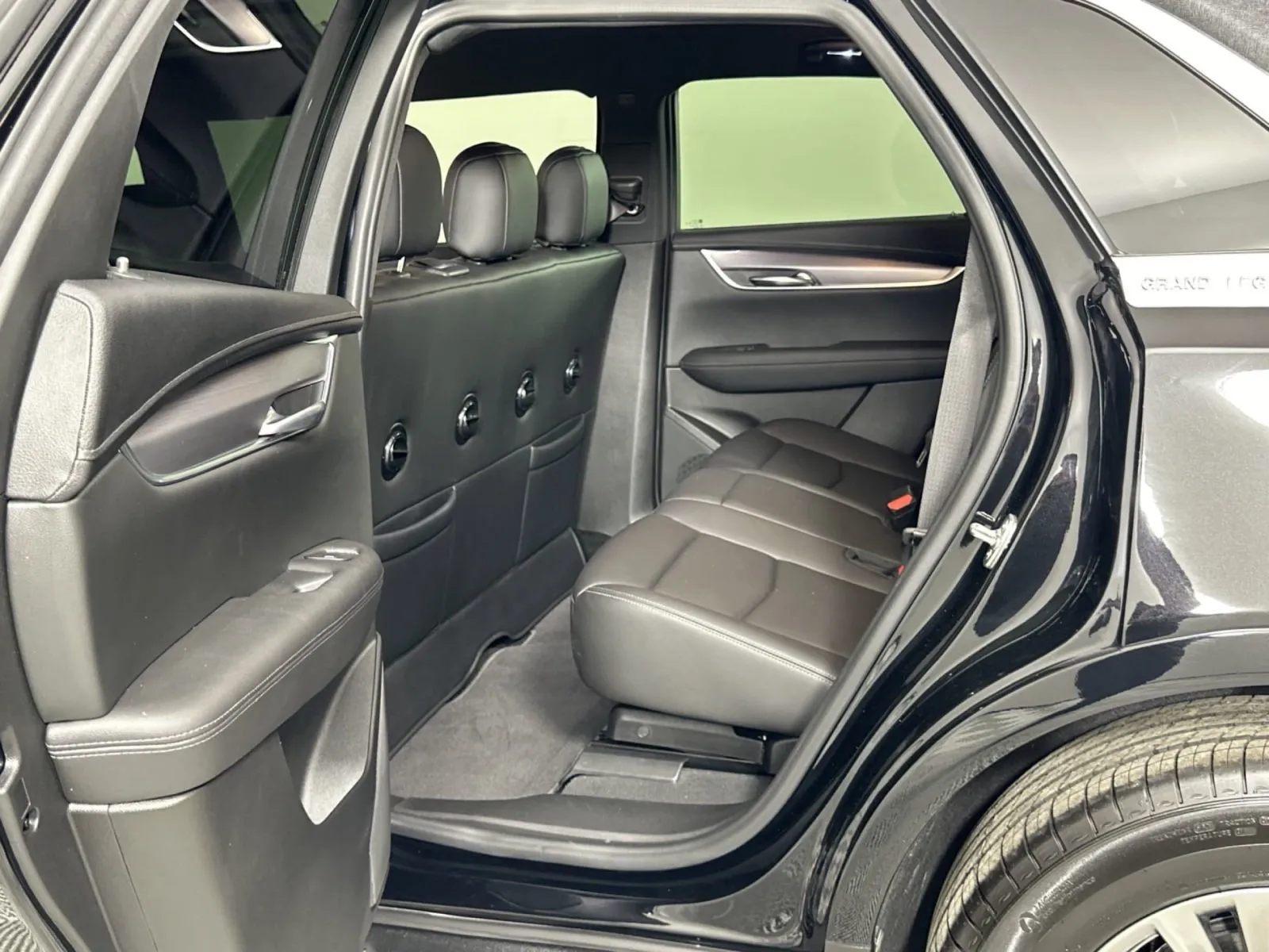 Interior view of a luxury SUV showing spacious black leather seating in the back.