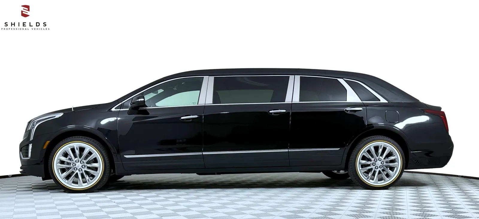 Elegant black limousine with chrome details, showcasing a modern sleek design on a checkered floor.