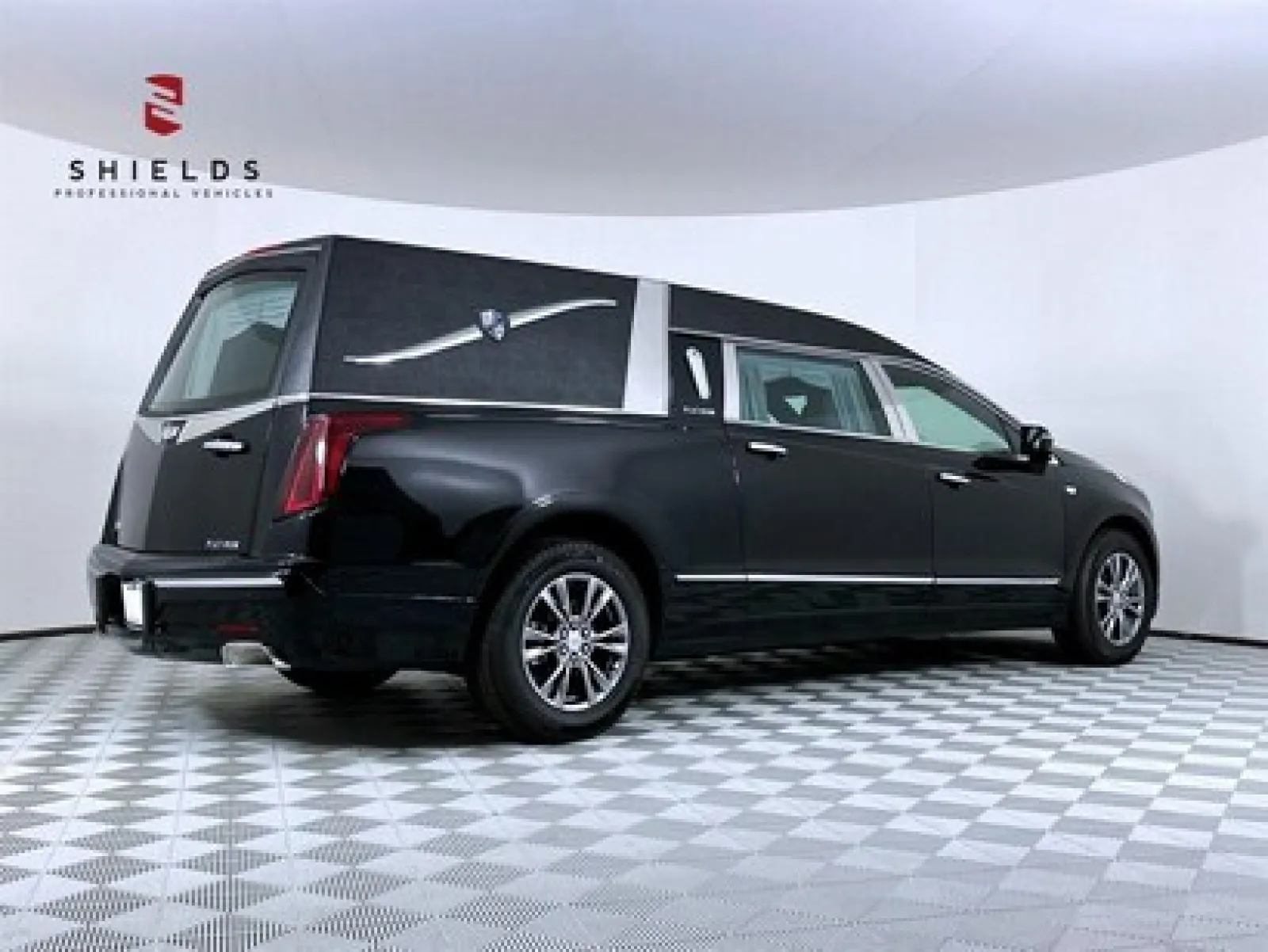Black hearse with sleek design, showcased in a professional studio setting.