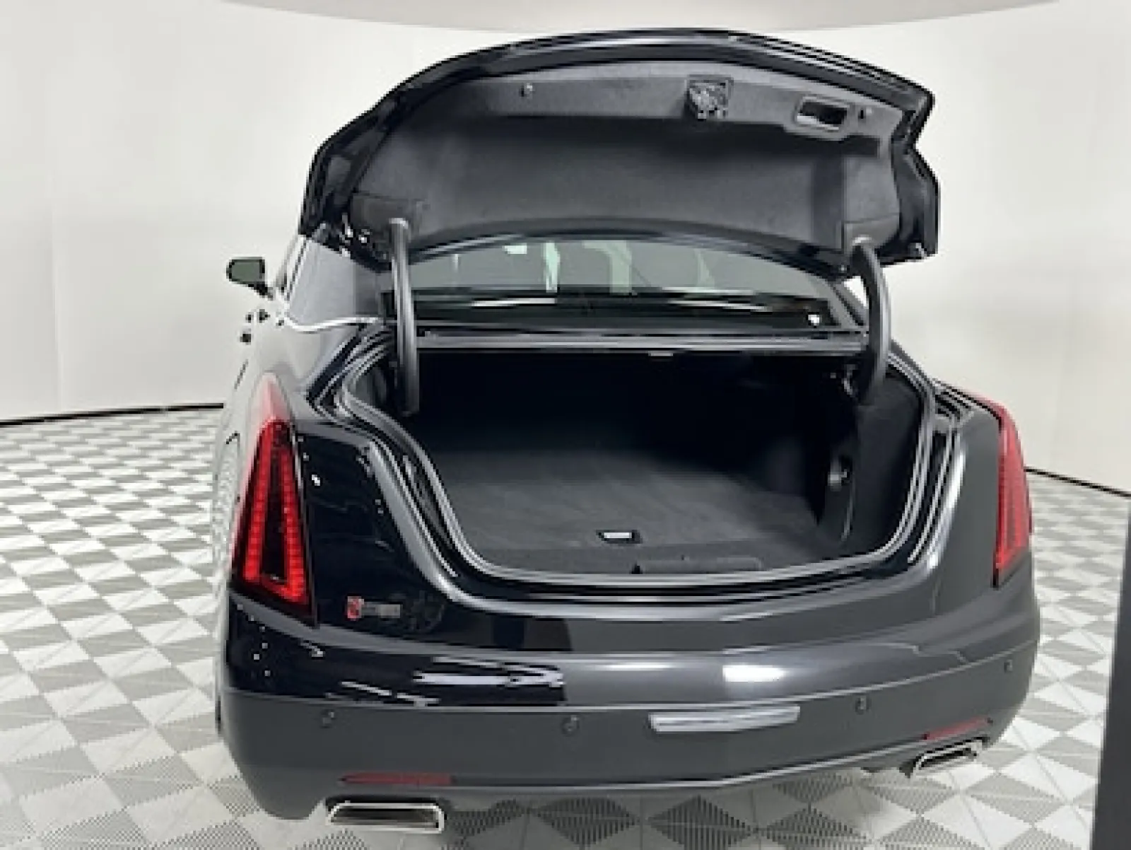 Luxury sedan with an open trunk, showcasing spacious cargo area and sleek design.