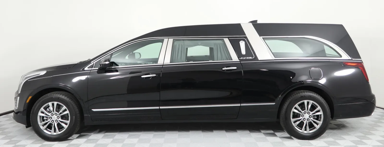 Side view of a black Cadillac hearse showcasing elegant design and sleek lines.