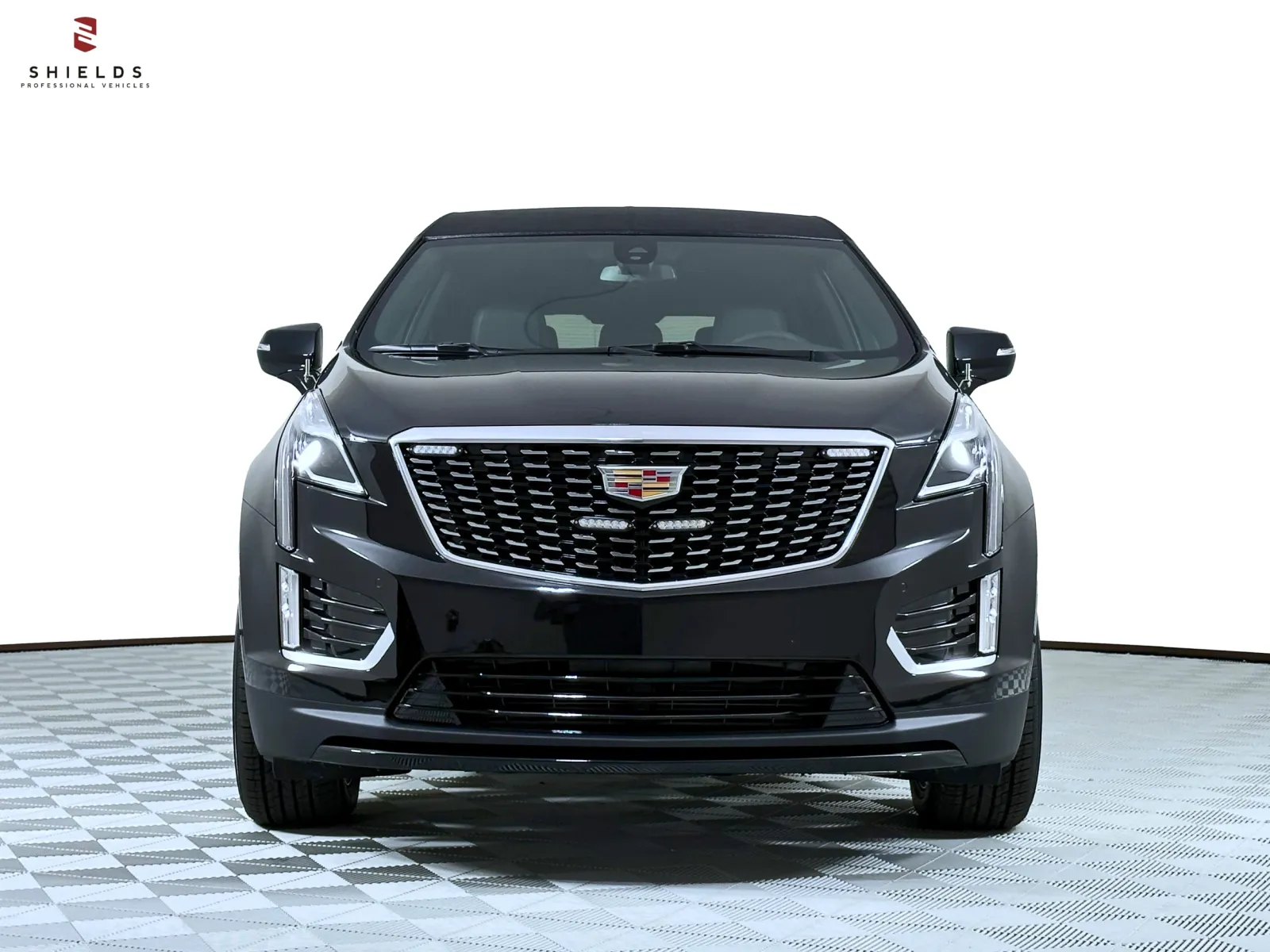 Front view of a sleek black Cadillac XT5 with a modern design and shiny grille.