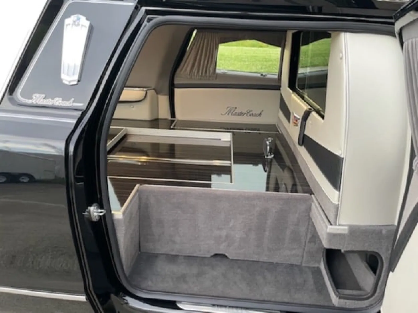 Interior view of a sleek black hearse with elegant finishes and spacious storage.