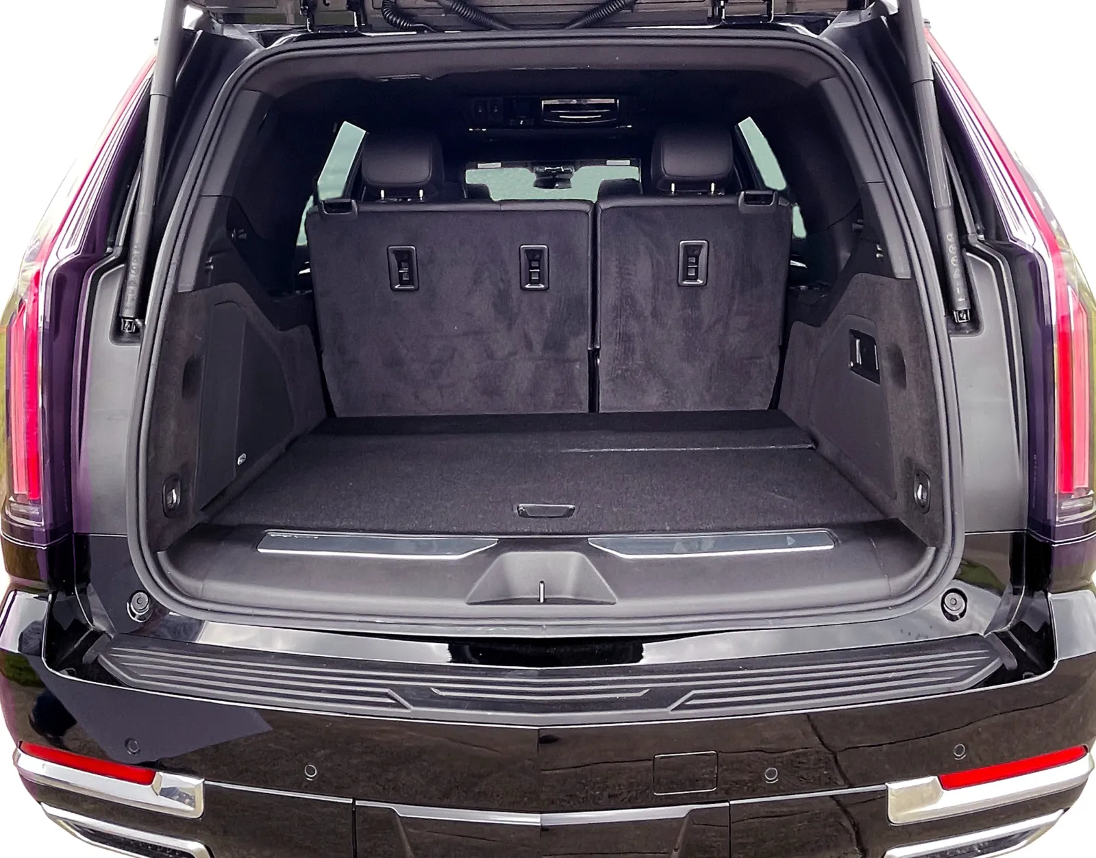 Open trunk of a black SUV showing spacious cargo area and folded rear seats in a clean interior.