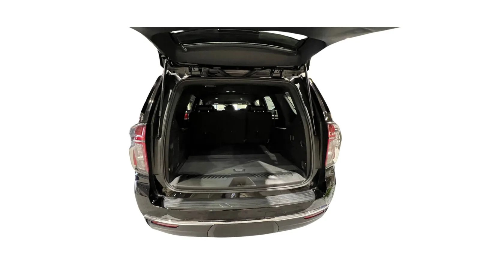 Interior view of a spacious black SUV trunk with a flat loading surface.