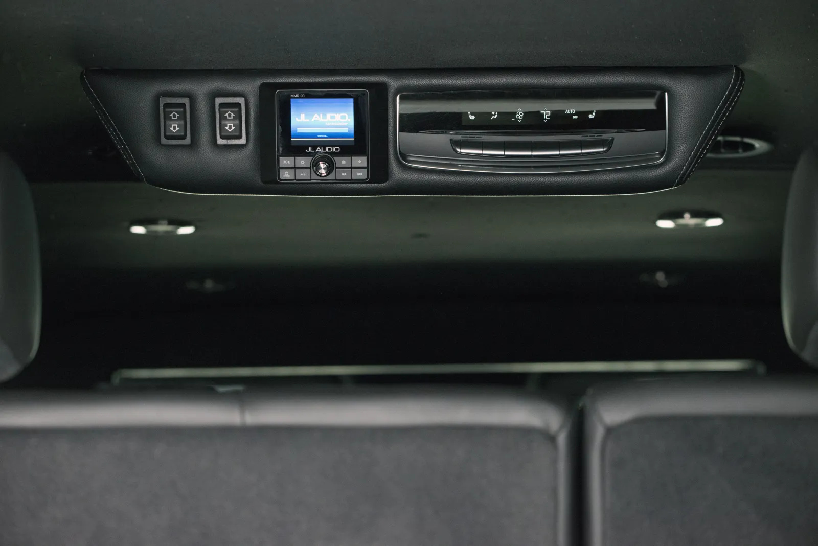 Car interior roof panel with JL Audio control screen and climate control buttons above rear seats.