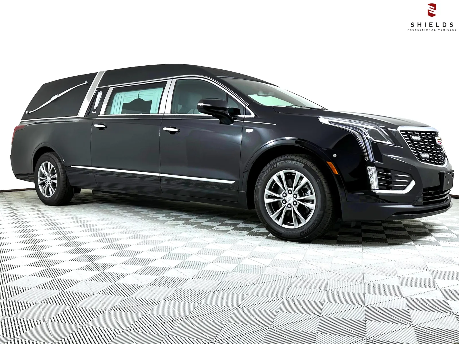 Sleek black Cadillac hearse showcasing modern design and elegance against a plain background.
