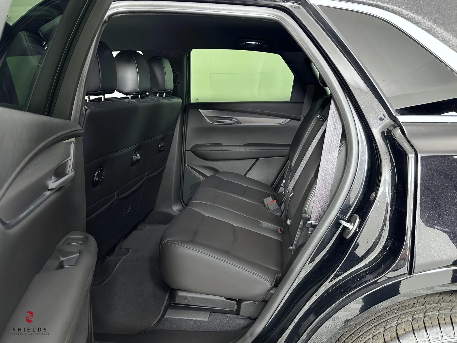 Interior view of a spacious SUV back seat with black leather seats and a clean design.
