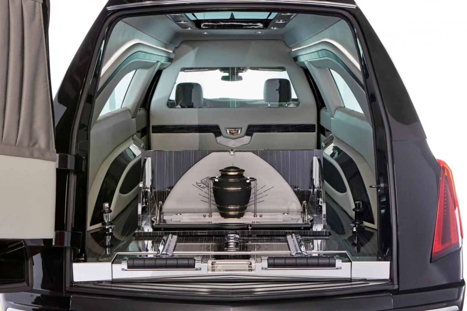 Interior view of a luxury hearse showing an urn and spacious seating.