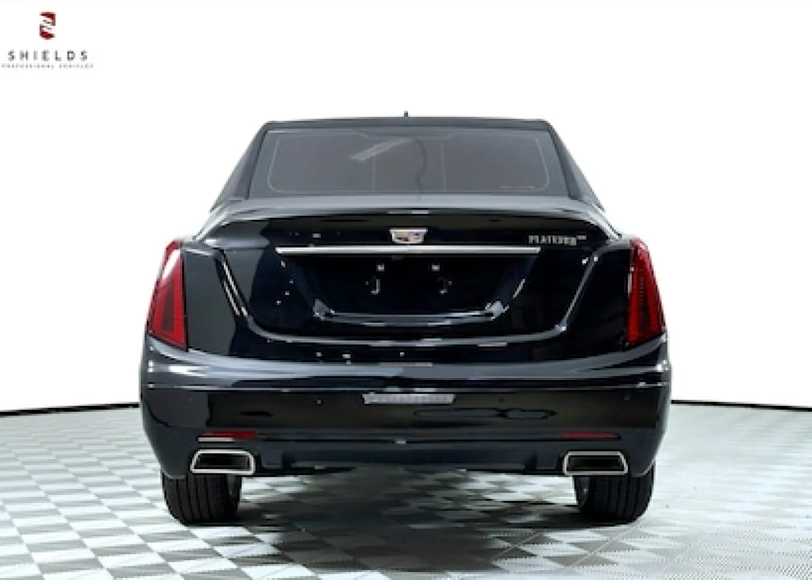 Rear view of a black Cadillac Platinum showcasing its sleek design and exhaust features.