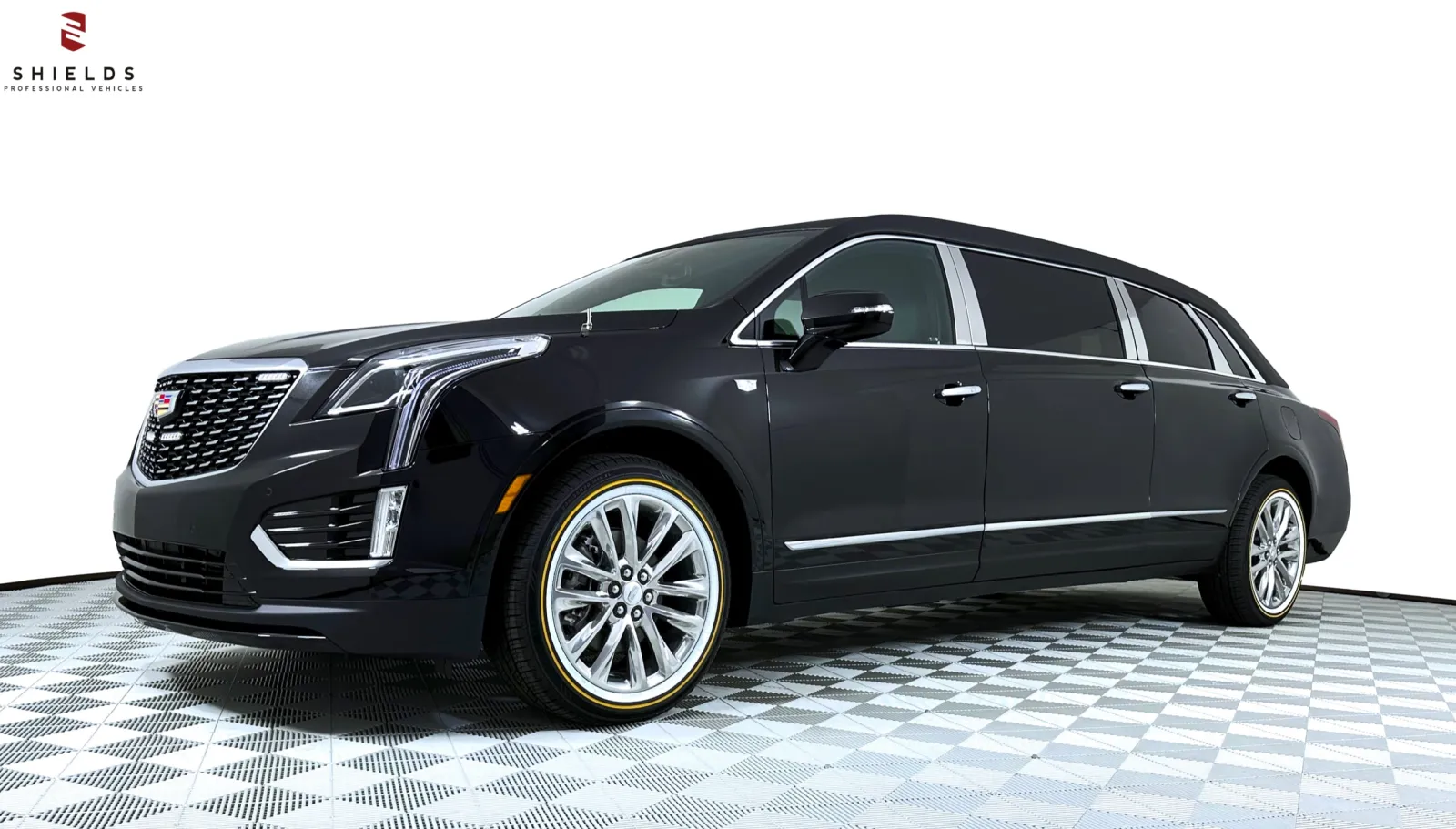 Sleek black Cadillac SUV limousine with elegant design and shiny wheels on a checkered floor.