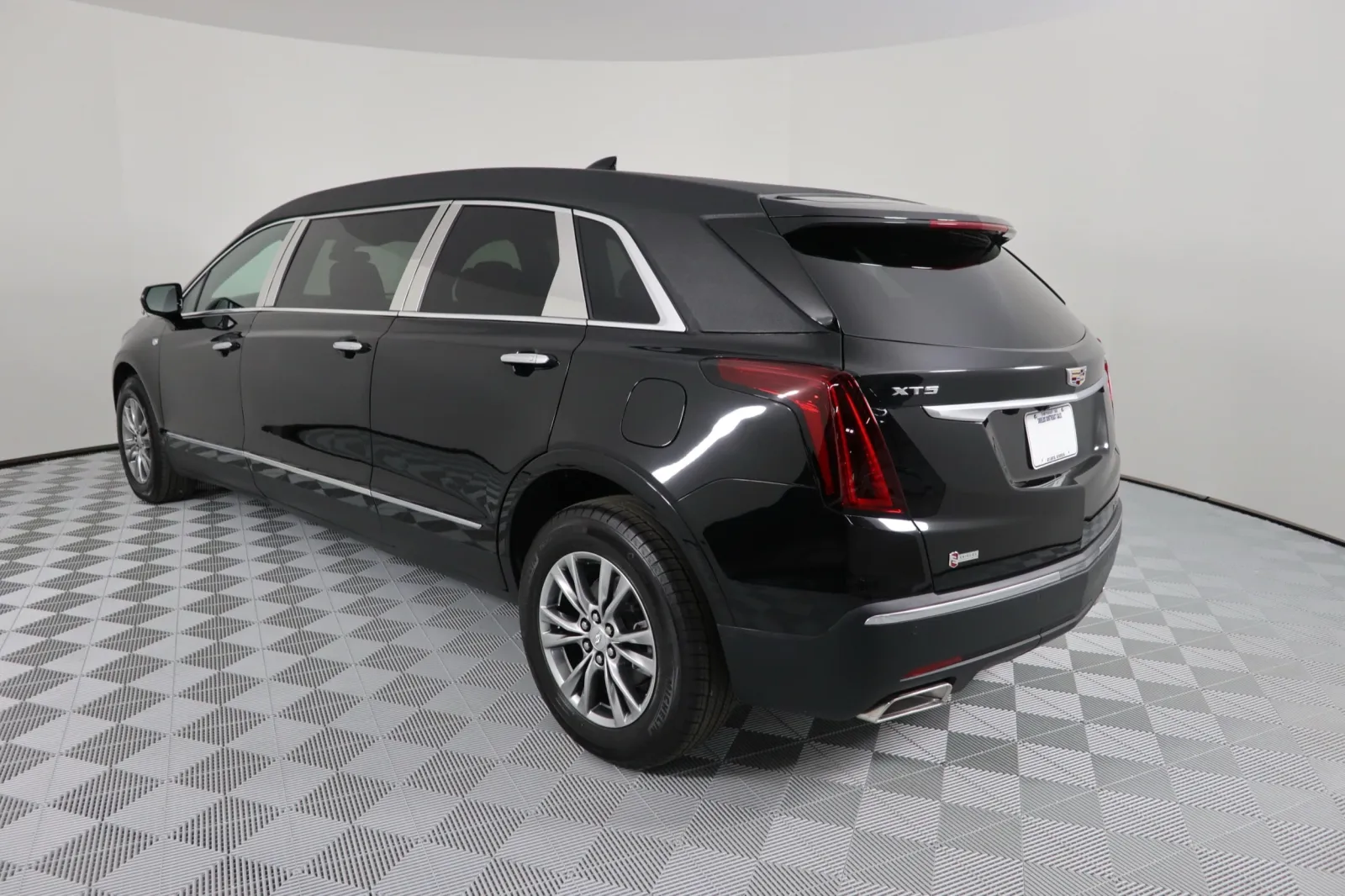 Black Cadillac XT5 rear view showcasing luxury and sleek design in a studio setting.