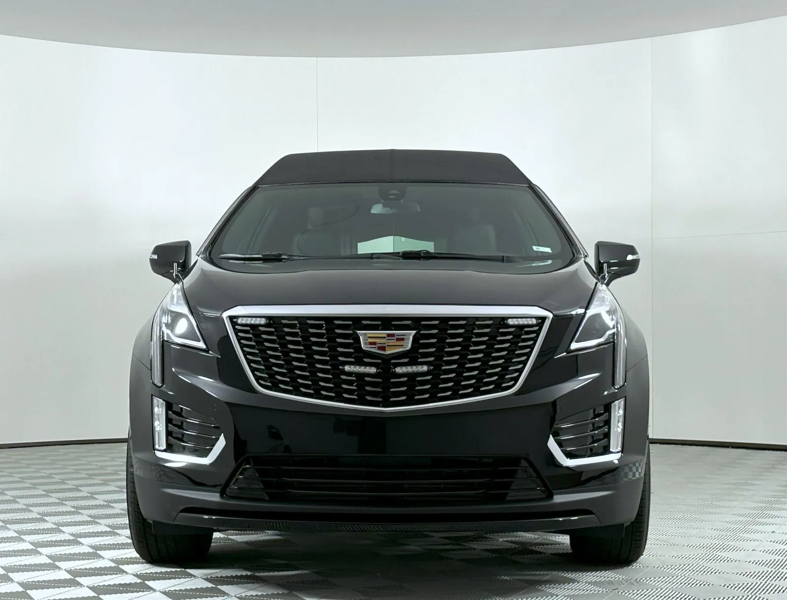 Front view of a sleek black Cadillac SUV with distinctive grille and modern design features.