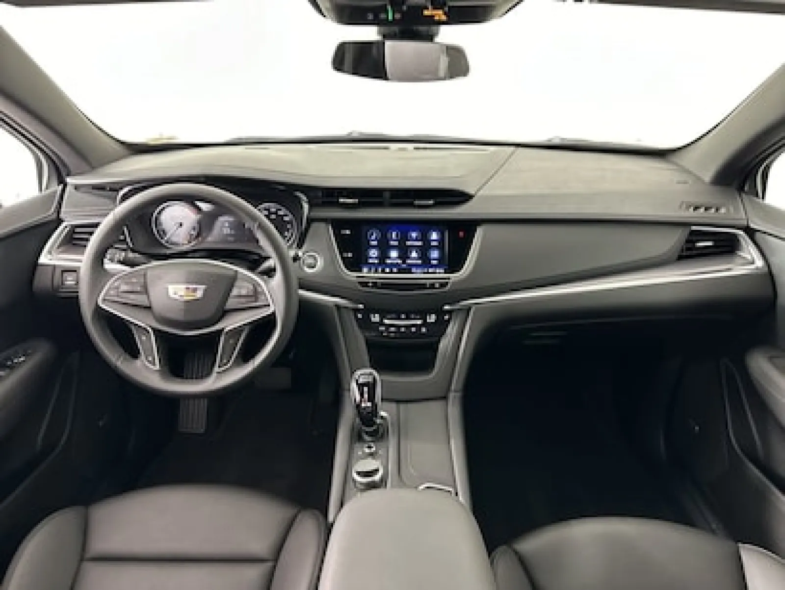 Sleek interior of a modern Cadillac showcasing the dashboard, touchscreen and leather seats.