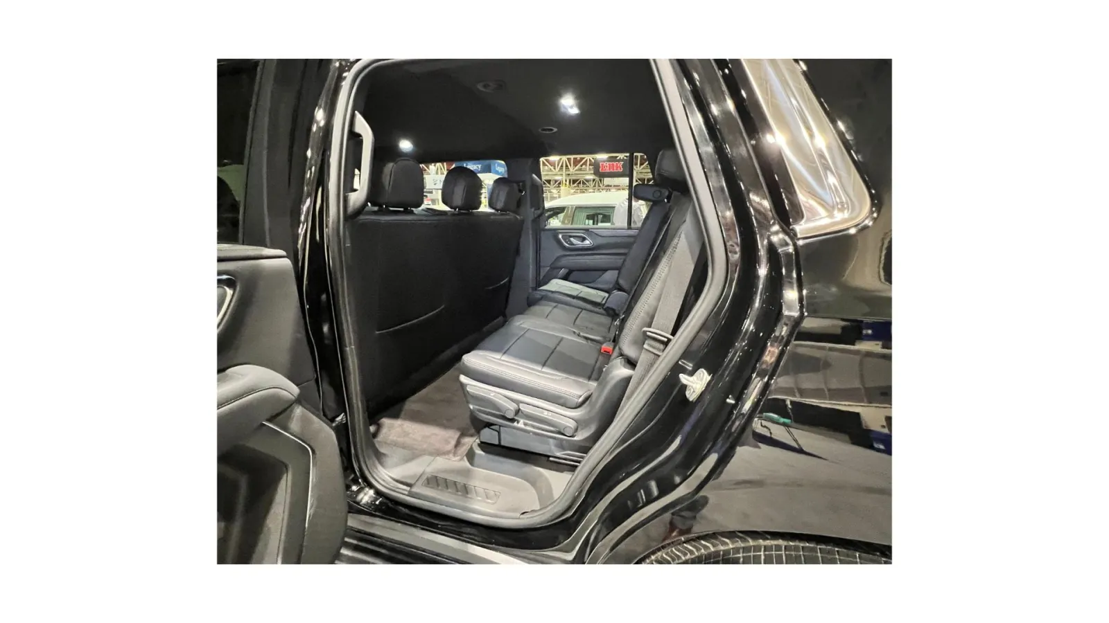 Interior view of a spacious black SUV showcasing rear seating and elegant design features.