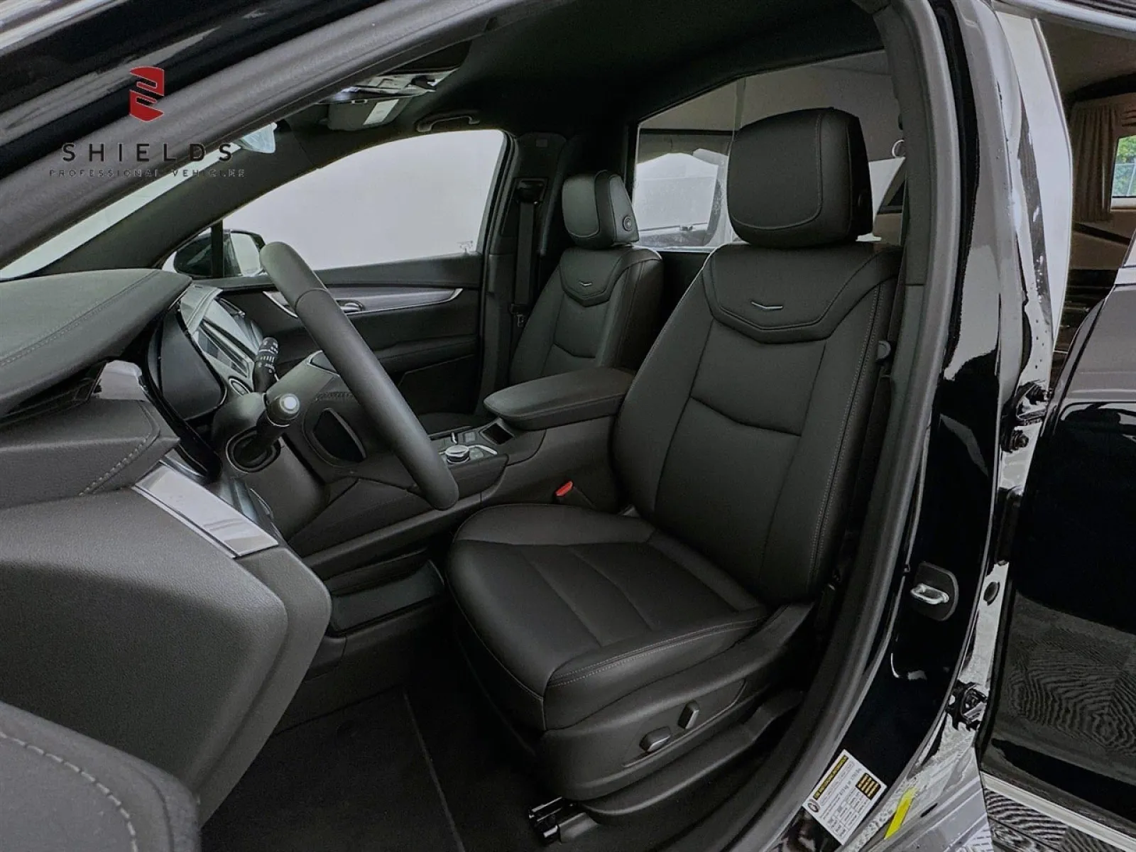 Interior view of a sleek black car showcasing leather seats and modern dashboard features.