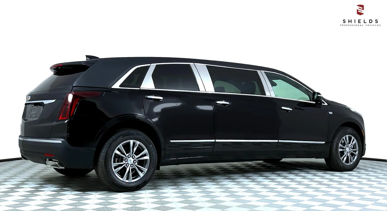 Black luxury limousine with sleek lines, parked on a patterned floor against a white background.