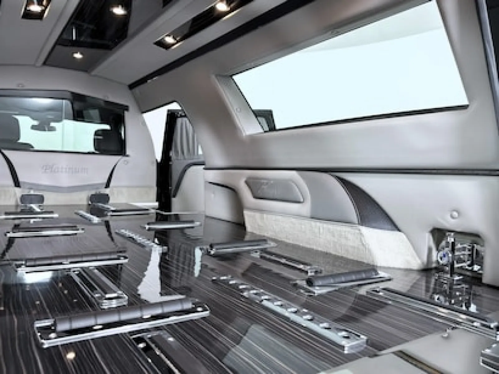 Luxurious interior of a limousine featuring polished surfaces and spacious seating arrangements.