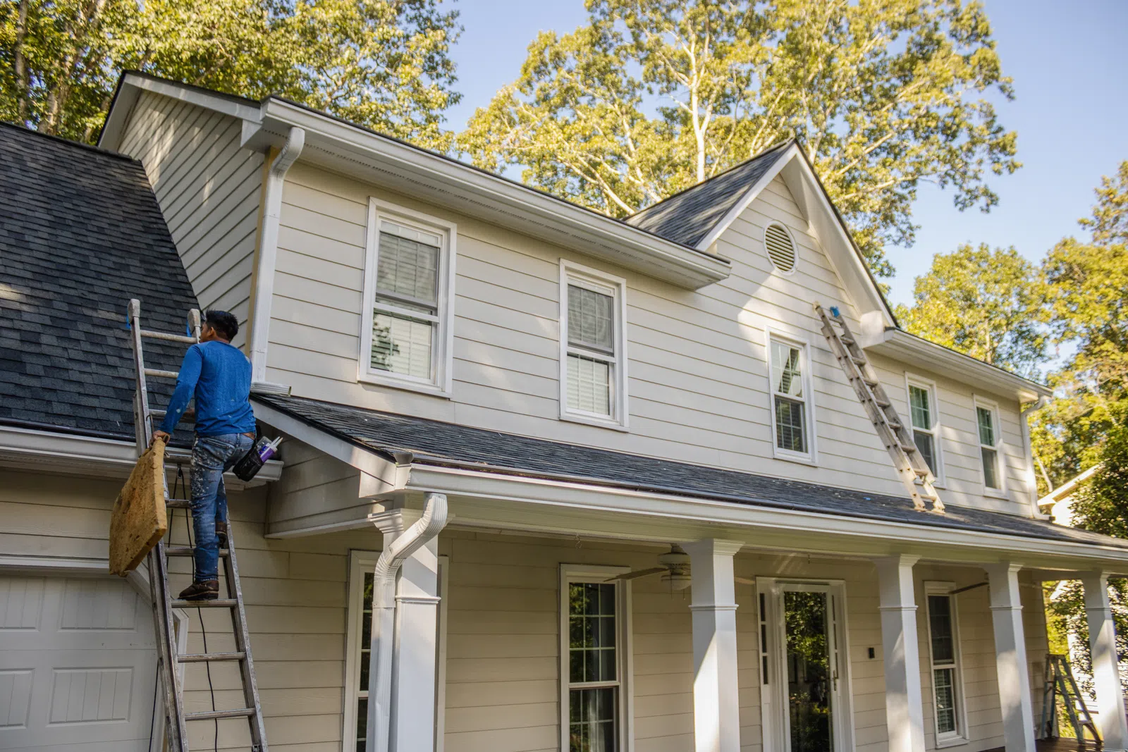 Exterior contractor climbing ladder for home renovation in Marietta by Nelson Exteriors