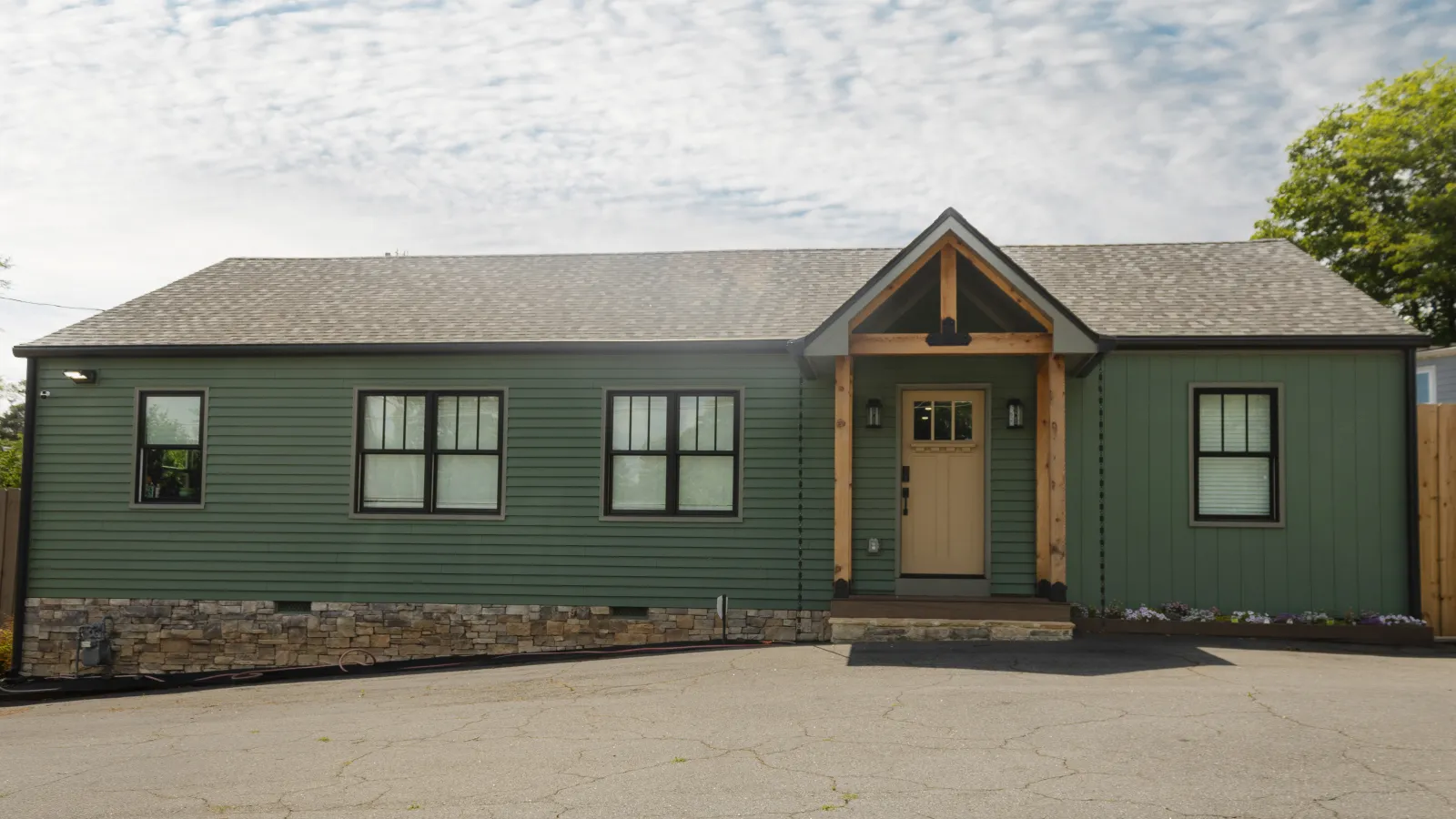 Green siding house with stone veneer and dark-trim windows upgraded by Nelson Exteriors in Marietta.