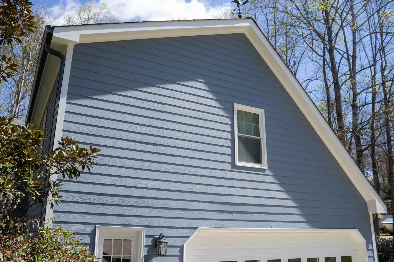 A two-story home garage gable featuring newly installed slate blue lap siding, demonstrating the durability of James Hardie vs other siding materials in Marietta by Nelson Exteriors.