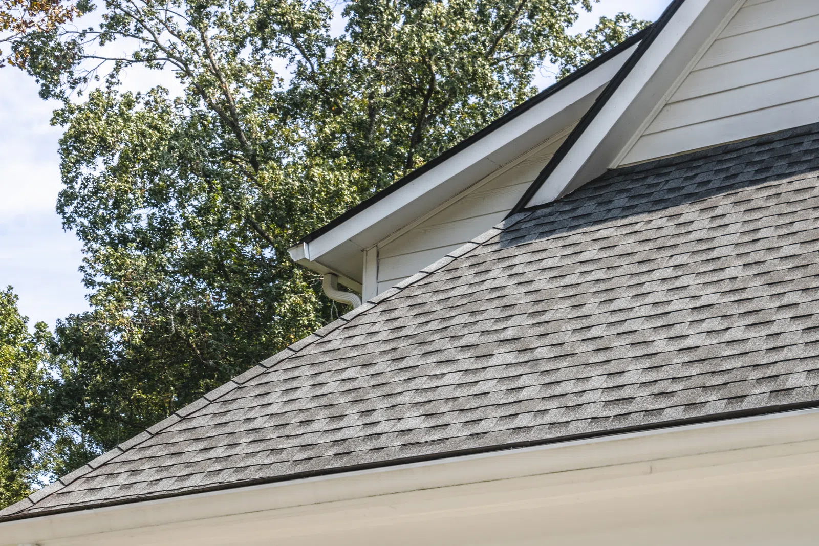 A roof with new dark shingles and a white gable, supporting workmanship vs manufacturer roof warranty in Marietta by Nelson Exteriors.