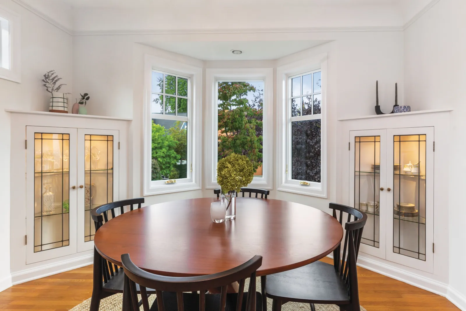 Energy-efficient white bay windows in a bright Nashville breakfast nook, featuring high-quality fiberglass frames and custom architectural details.