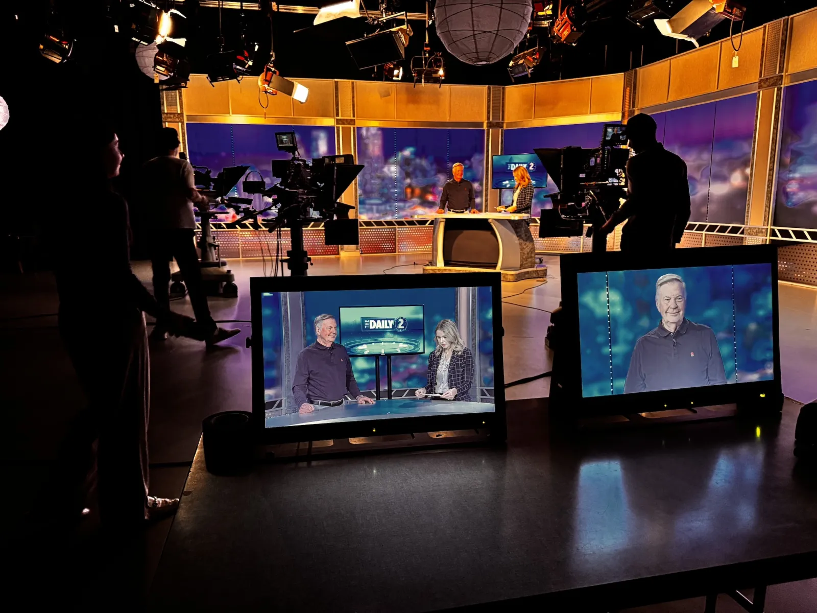 a group of people standing around a display of televisions