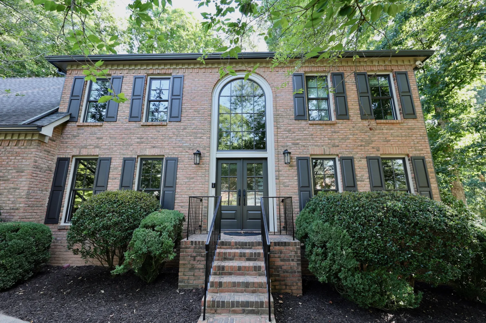 brick home with new bronze fiberglass windows and a double entry door