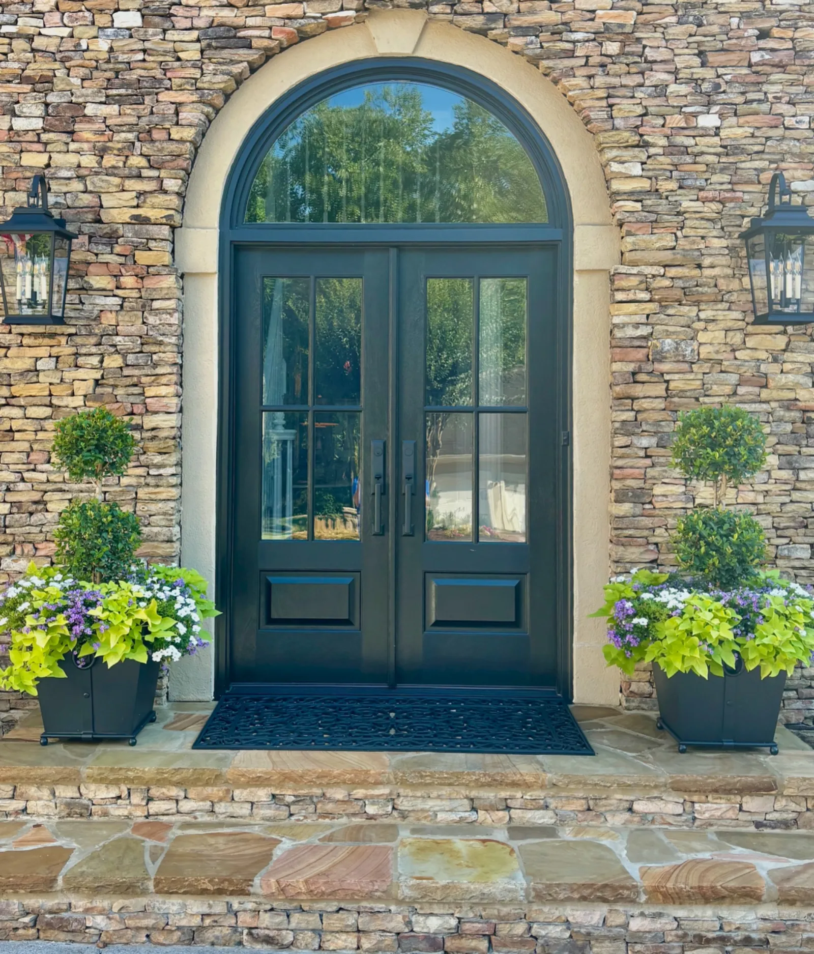 Arched black double front doors with transom