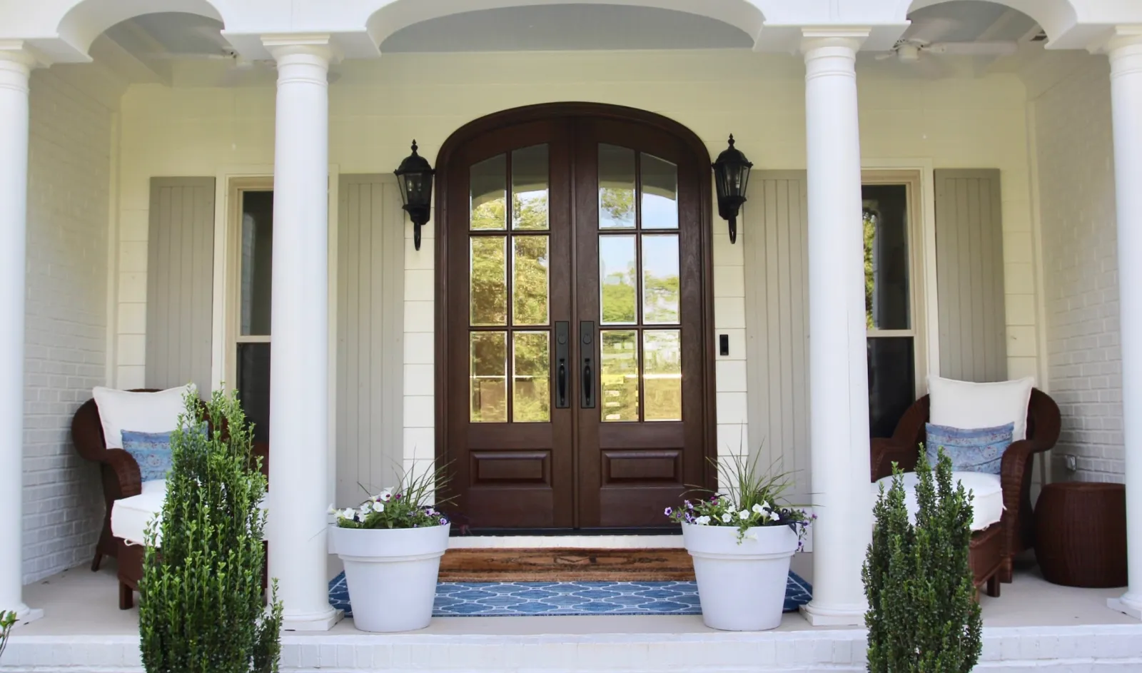 a door with pillars and plants in front of it