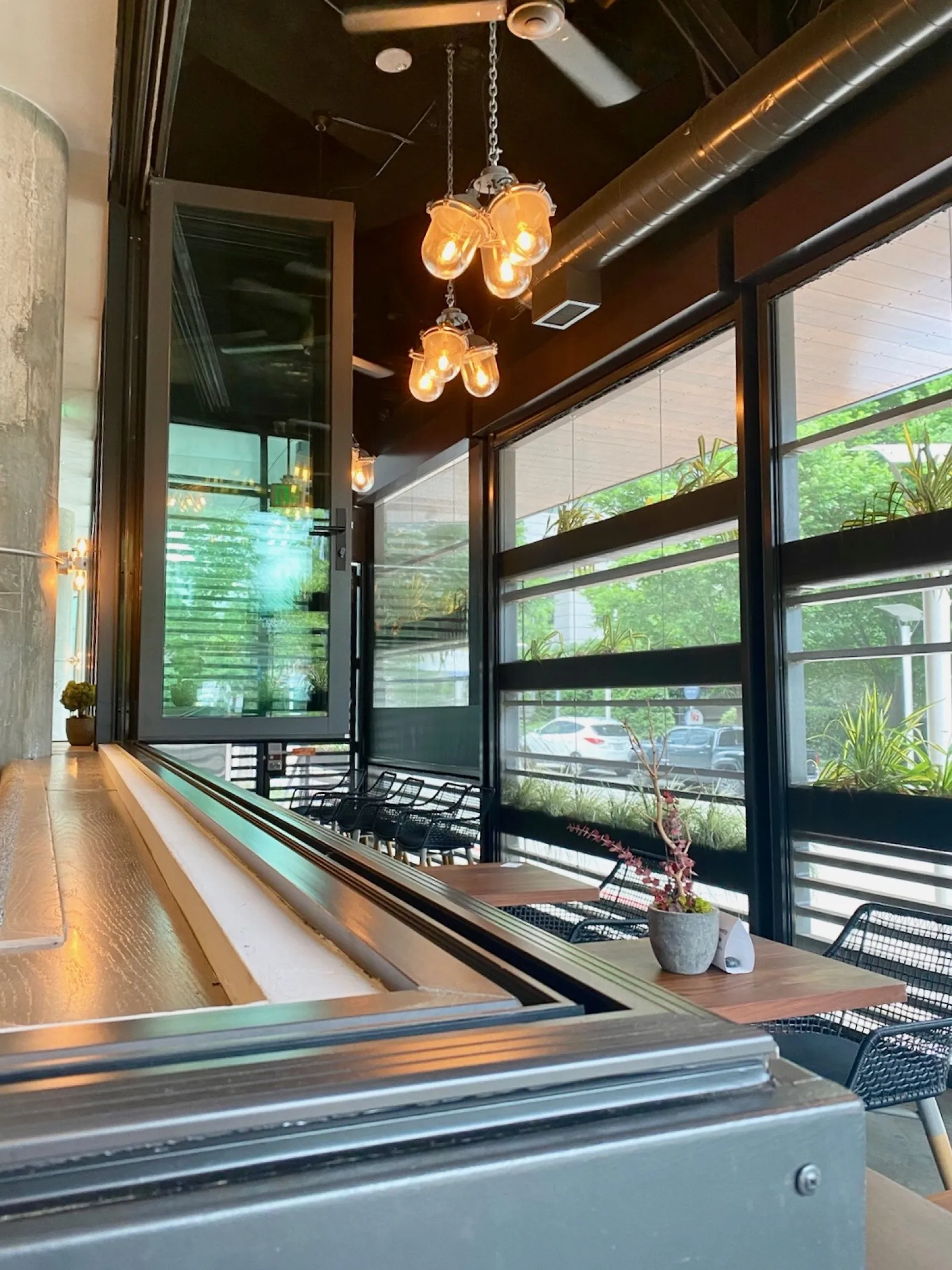 a room with a table and chairs and a large window with a view of the street