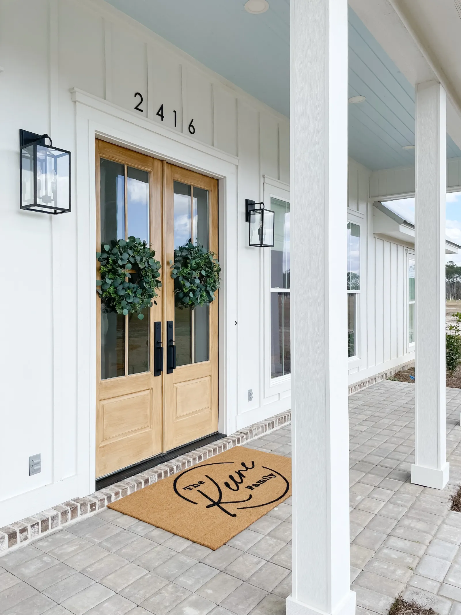 Double wood and glass front door on a white house