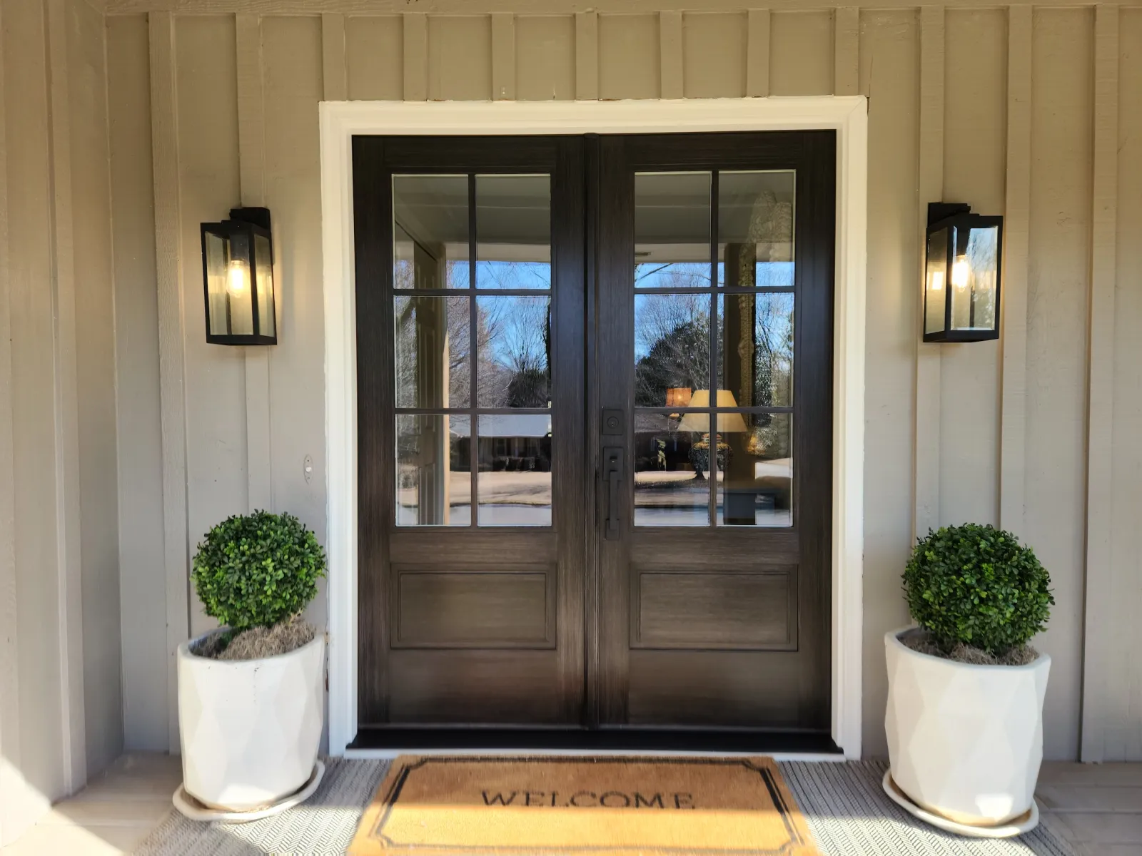 Stained double front doors installed on board and batten house