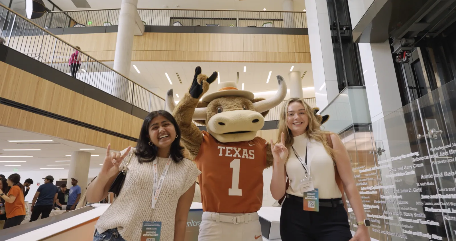 a couple of women posing with a mascot