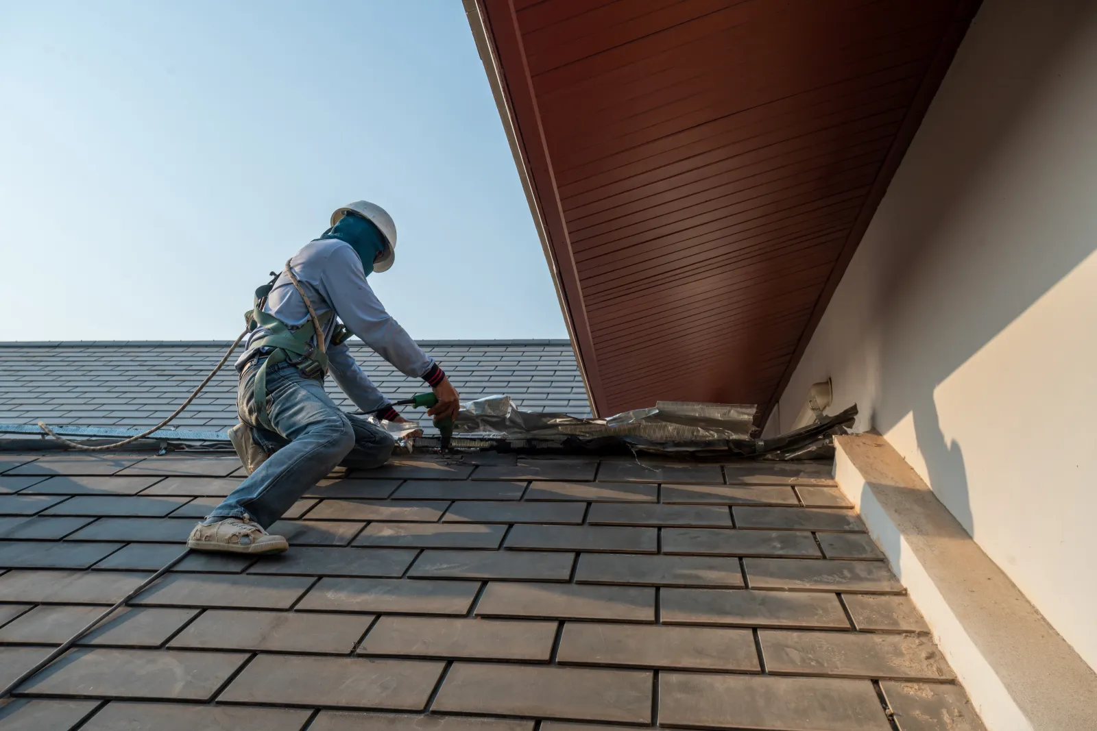 Roof worker stapling shingles